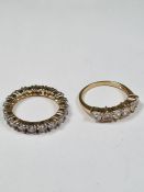 Two 9ct gold rings, one a cubic zirconia set eternity ring, and the other a half hoop example, both