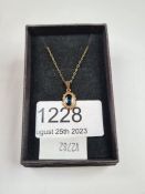 Fine 9ct gold necklace hung with a pendant with central oval mixed cut sapphire in ropewtist frame,