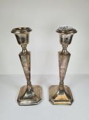 A pair of silver candlesticks by Clark and Sewell, Birmingham 1917. Having tapering columns, AF, 23c