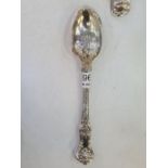 A pair of decorative silver serving spoons, having embossed decorative handles. Hallmarked London 18