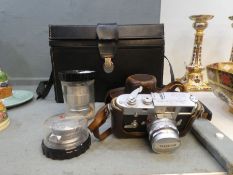 A vintage Leica M2 camera with leather case, two additional Leica lenses and other sundry related it