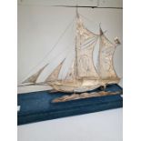 A cased white metal boat having a seated figure sailing. Very ornate and decorative pierced details,