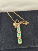 Fine 9ct yellow gold neckchain hung with a 9ct yellow gold line pendant set emeralds and small diamo