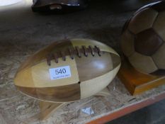 A wooden decorative football and a similar Rugby ball