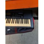 Yamaha Keyboard and stand with a box of sheet music. Model PSR-320