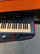 Yamaha Keyboard and stand with a box of sheet music. Model PSR-320