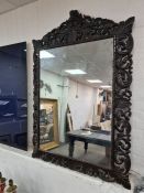 A large carved oak wall mirror having pierced scroll decoration, 98cm approx
