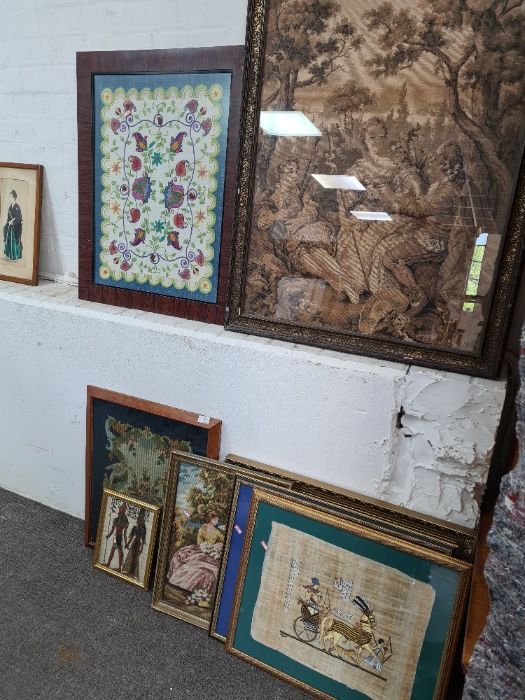 A quantity of needlework pictures, Egyptian style picture and others