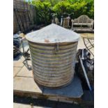 An old galvanised circular storage bin having pointed lid