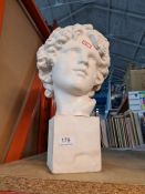 A plaster bust on plinth of a female