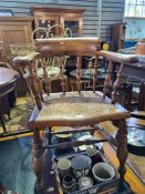 An old oak desk chair having turned spindleback with cane seat