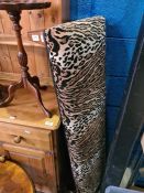 A long footstool having leopard style upholstery