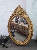 A modern antique style oval wall mirror having gilt frame