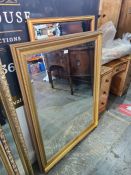 Two modern gilt framed bevelled wall mirrors, the largest 130cms