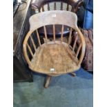 An old stripped oak revolving desk chair having spindle back