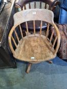 An old stripped oak revolving desk chair having spindle back