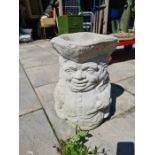 A concrete planter in the form of a Toby jug and three others