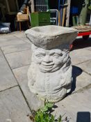 A concrete planter in the form of a Toby jug and three others