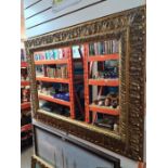 A reproduction gilt framed mirror, depicting Brighton Pier, having bevelled glass