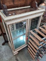 A white painted and gilt decorated two door display cabinet