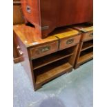 A pair of reproduction bedside tables having military style handles each having two drawers and open