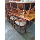 A set of 6 1970's G Plan dining chairs having carved fox rail and an extending teak dining table wit
