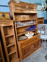 An old stripped pine dresser, the rack back having top cupboard