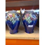 A pair of Doulton stoneware vases, decorated flowers and fruit