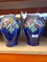 A pair of Doulton stoneware vases, decorated flowers and fruit