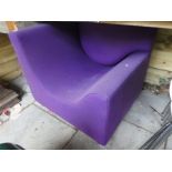 A modern corner chair of square shape with purple upholstery