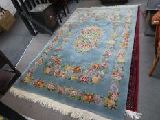 A modern Chinese rug having floral design in a turquoise field, 252cm x 157cm