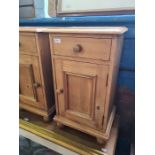 A pair of modern pine bedside cupboards having one drawer and one other matching cupboard