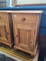 A pair of modern pine bedside cupboards having one drawer and one other matching cupboard