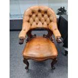 A Victorian mahogany desk chair having leather buttoned back and seat on carved cabriole legs