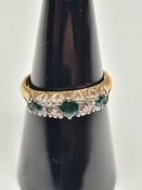 18ct yellow gold band ring set with round cut emeralds, set small round cut diamonds, marked 18ct, s