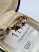 18ct yellow gold dress ring set with seed pearls and rubies in raised Scrollingmount, marked 18K, si