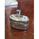 A white metal oval cricket holder having pierced sides