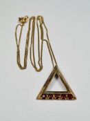 9ct yellow gold triangular pendant set with 5 garnets, marked 375, hung on yellow metal fine chain