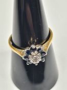 18ct yellow gold cluster ring with central illusion set diamond surrounded sapphires, size O, marked