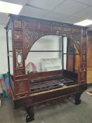 An old Chinese carved hardwood bed having red and gilt decorated canopy, freize and sides, 216cm lon