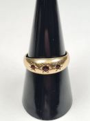 9ct yellow gold band ring with 3 small starburst set garnets, size Q, marked 375, maker JSM, Birming