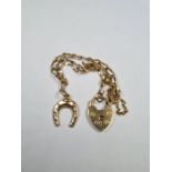 9ct yellow gold bracelet with heart shaped clasp hung with a 9ct gold, horseshoe charm, safety chain