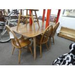 An Ercol oblong dining table and a set of 7 Ercol stickback kitchen chairs