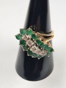 14K yellow gold dress ring set with central row of central diamonds surrounded emeralds in crossover