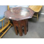 A Far Eastern octagonal occasional table on folding base having lacquer style decoration, 61.5cm