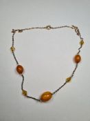 Yellow metal necklace set with 3 amber beads, and 3 faceted triangular amber beads, unmarked