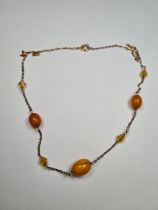 Yellow metal necklace set with 3 amber beads, and 3 faceted triangular amber beads, unmarked