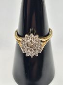 18ct yellow gold diamond cluster ring, with oval form cluster on raised claw mount and split shoulde