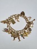 9ct yellow gold charm bracelet hung with approx 19 charms, 9ct gold and yellow metal to include 9ct