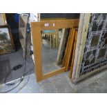 A modern oak oblong wall mirror and two other pine framed mirrors